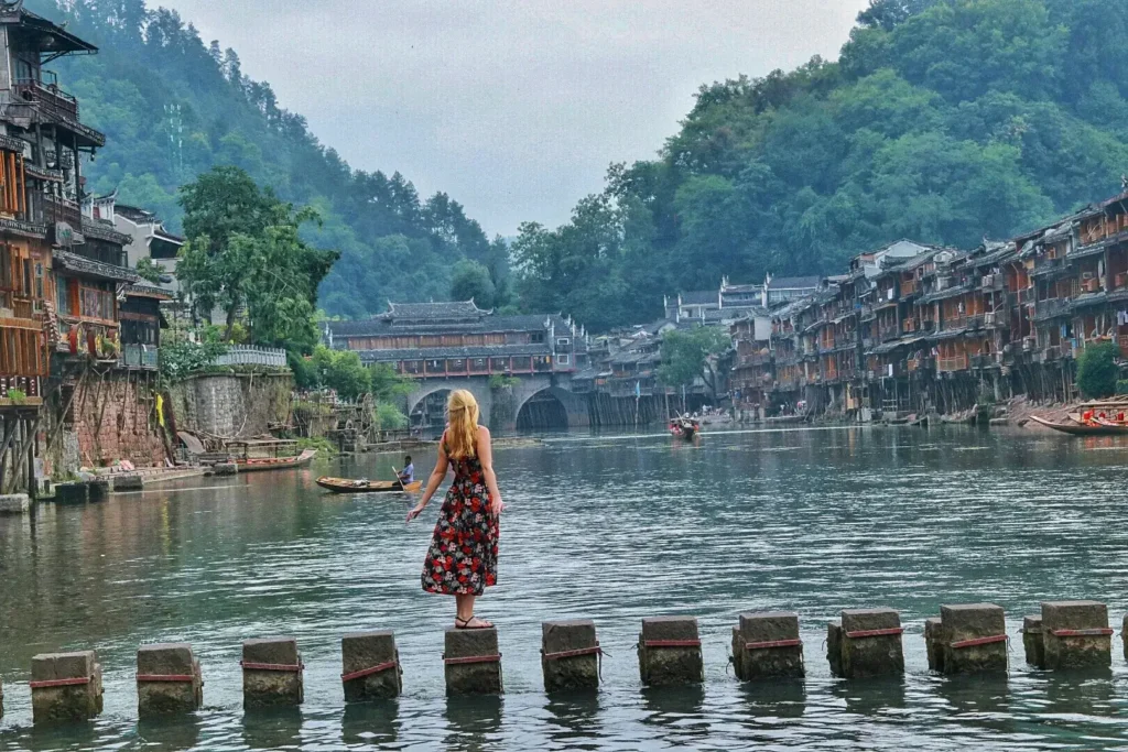 tourist on the bridge of phoenix ancient town