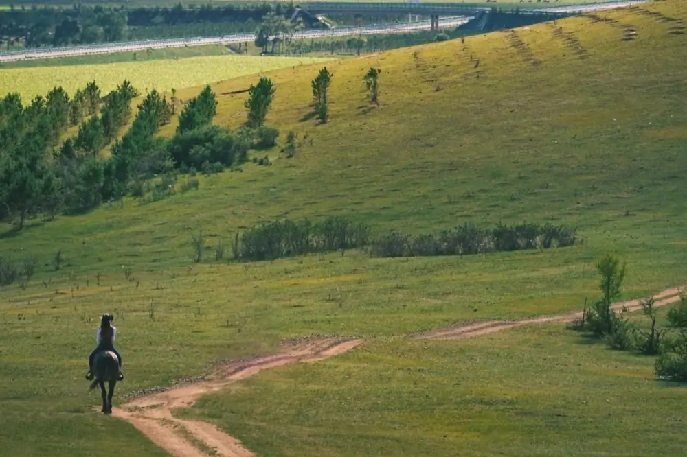 China Holidays 2025–2026: Public Holidays & School Breaks Travel Guide 8 A lone rider on horseback crossing open grasslands near Beijing during autumn